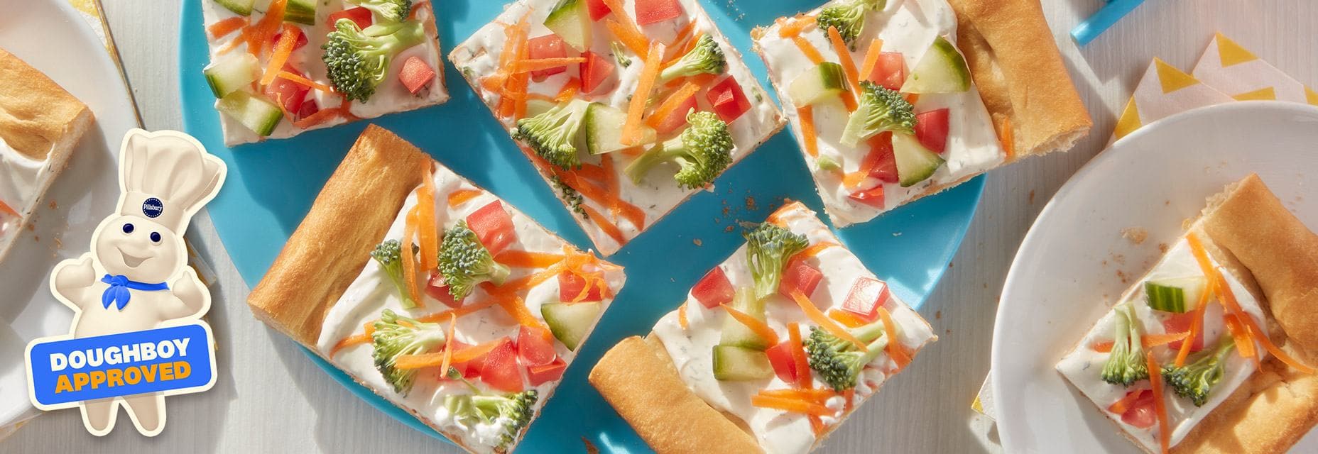 Veggie pizza slices with red peppers, carrots and broccoli.