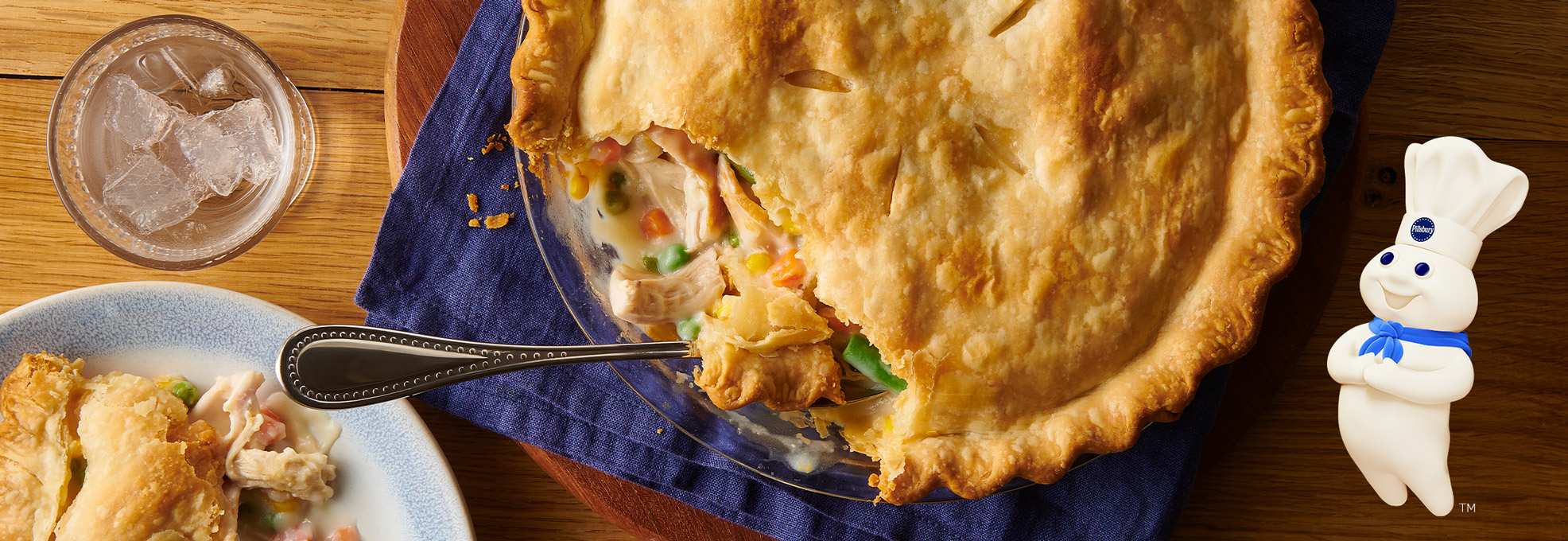 Baked chicken pot pie with a slice missing, and a serving on a plate.