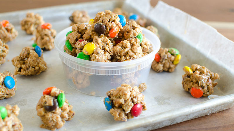 Monster Cookie Granola Bites prepared recipe on a baking tray and in a to-go container 