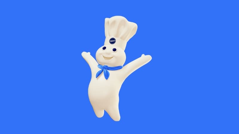 Pillsbury Doughboy in a happy pose, arms extended, on a blue background.