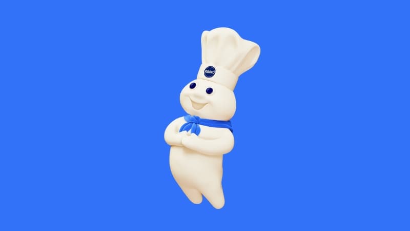 Pillsbury Doughboy on a blue background, smiling and holding his hands in front of his tummy.