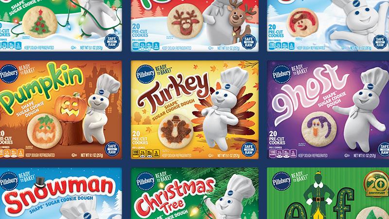 Colorful variety of holiday and seasonal Pillsbury cookie dough packages, all featuring the Pillsbury Doughboy.