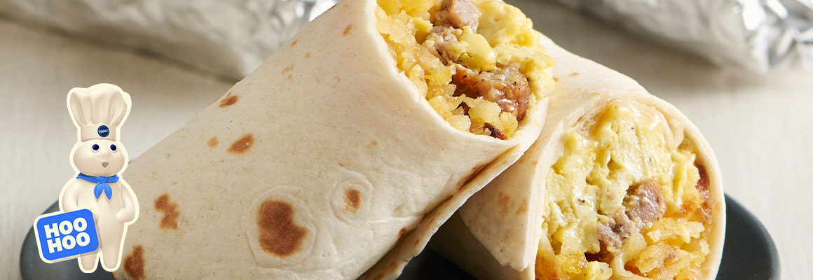 Crescent ring stuffed with chicken and cheese with broccoli and glass of milk nearby.   